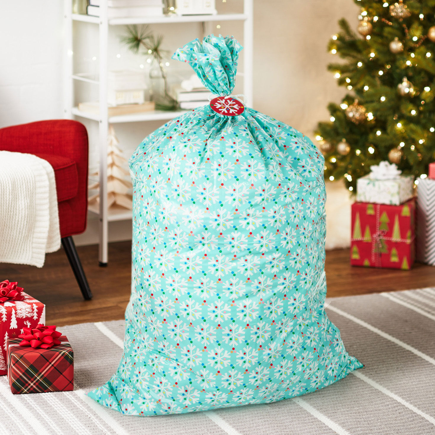 Snowflakes on Blue Giant Plastic Holiday Gift Bag in use image number 2