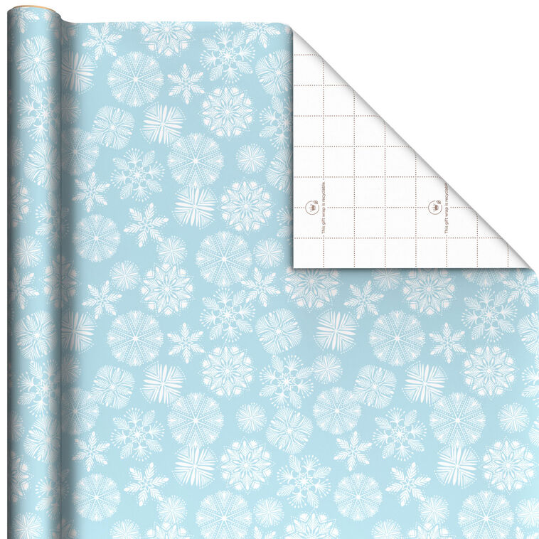 A roll of blue wrapping paper with white snowflakes on it