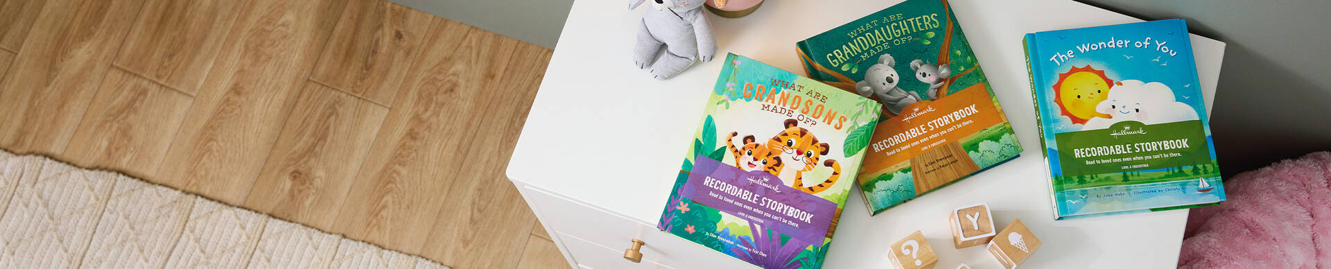 Three recordable storybooks on a dresser in a childs room.