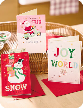 Three Christmas cards with iconic holiday icons and phrases