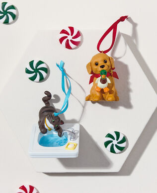 Two animal themed ornaments on a white background with unwrapped peppermints.