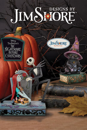Jim Shore Nightmare Before Christmas Sally and Jack with tombstone and black cat on book of spells figurines on table with pumpkins.