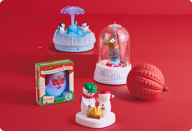 Four holiday-themed ornaments on a red background.