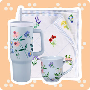Delicate floral patterns on a blanket, mug and water cup.