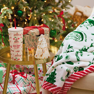 Holiday Ever After water cup and blanket, and Christmas tree candle holder.
