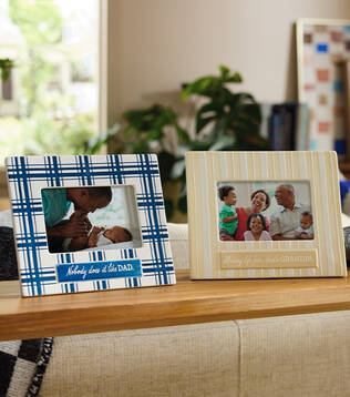 Two Fathers Day frames on a wooden tabletop. 