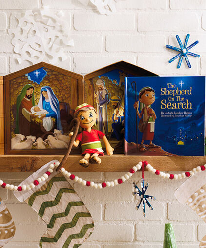 Decorated mantel with nativity, stockings, garland and book The Shepard on the Search