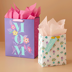 Gift bags with floral designs, one of them reads "MOM"