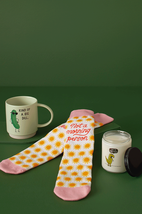 A mug, pair of socks and a candle with humorous sayings on them.