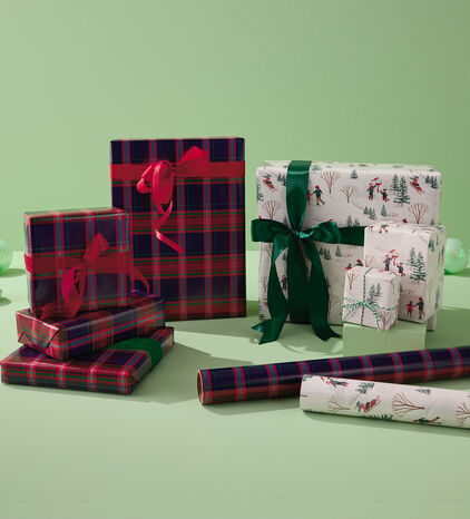 Red and green plaid gift wrapped gifts and winter scene gift wrapped gifts.