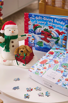 2024 singing snowman plush with coordinating book and puzzle on a table.