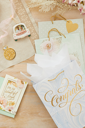 Wedding-themed gift bags, ornaments and a card displayed on a table