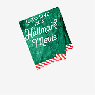 Green blanket with a red and white striped border that says My Christmas wish is to live in a Hallmark movie'