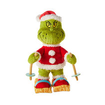 The Grinch dressed in a Santa suit with skis and skiing poles