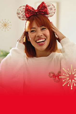 woman smiling and wearing Holiday Ever After themed Minnie Mouse ears.