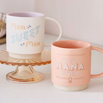 White mug with ‘Mom sweet Mom’ on it and a pink mug with ‘Best Nana ever’ on it