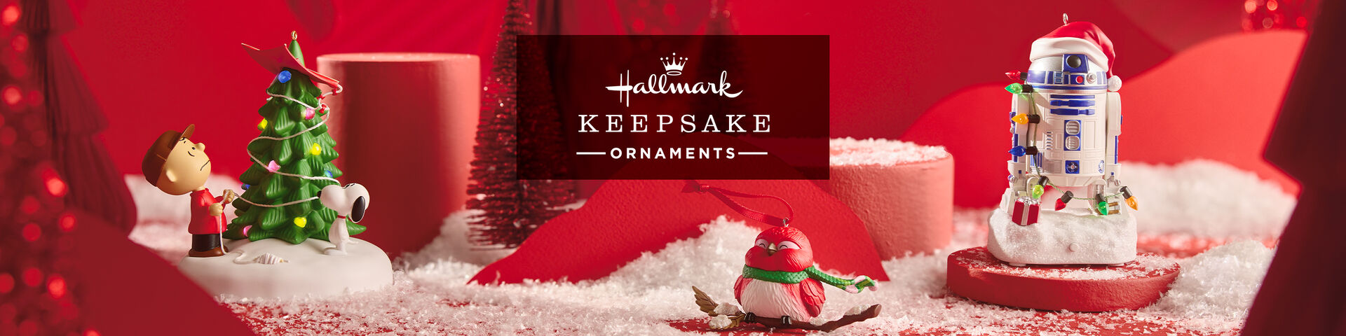 Hallmark Keepsake Ornaments logo and ornaments with snow on red background