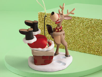 Ornament depicting Santa stuck upside down in a chimney with laughing reindeer taking a photo