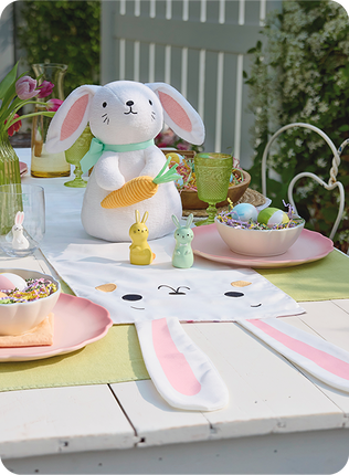Picnic table decorated with Easter Bunny decor for a party.