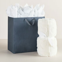 Extra large gift bag next to throw blanket.