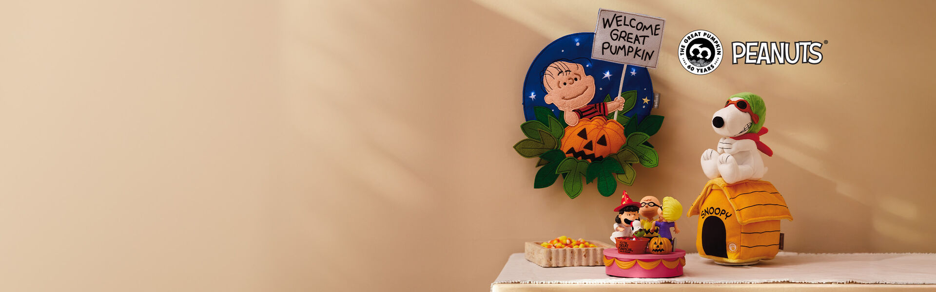 Peanuts Halloween gifts and decor on a table and hanging on the wall. 