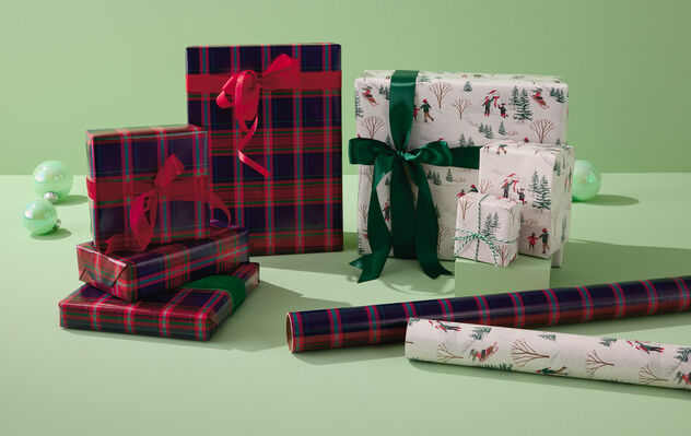 Red and green plaid gift wrapped gifts and winter scene gift wrapped gifts.
