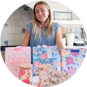 Lindsay Arnold in kitchen with Hallmark gift bags, candles and card.