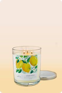 Lit three-wick candle in glass jar with lid