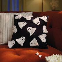 Square, black pillow embroidered with white ghosts