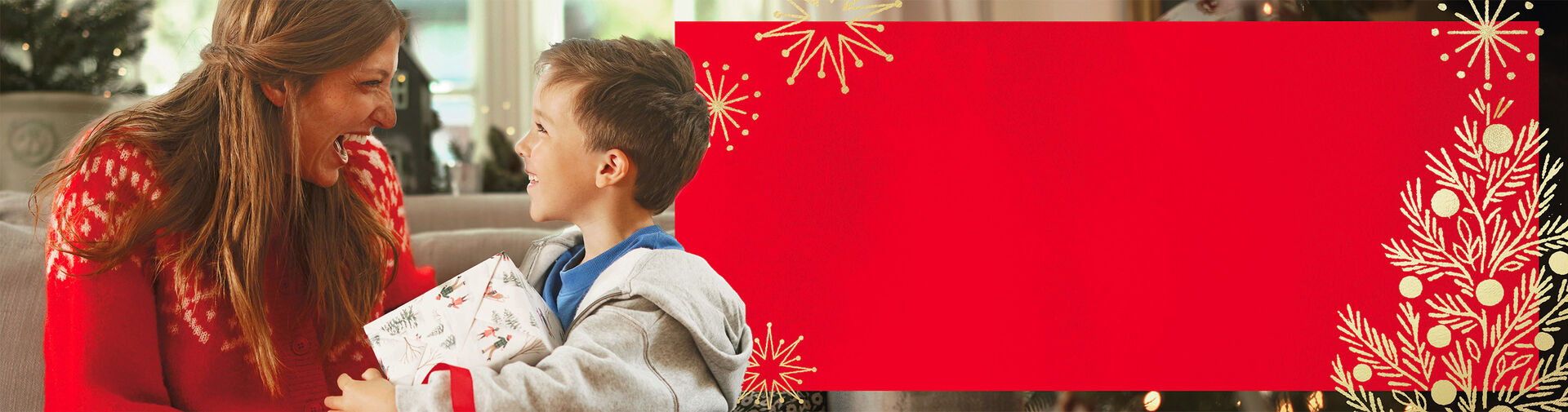 Woman and son laughing together while the son holds a present.