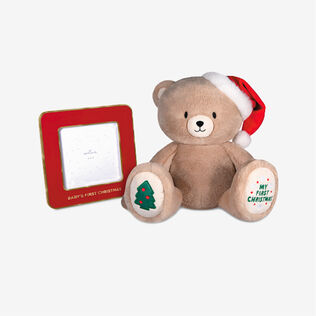 A plush bear with a Santa hat and red enamel frame
