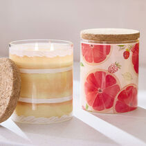 Candle with a layered cake design and candle with raspberry and grapefruit slice design.