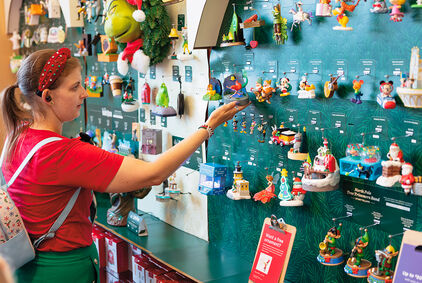 Woman looking at the Keepsake Ornament wall in store.