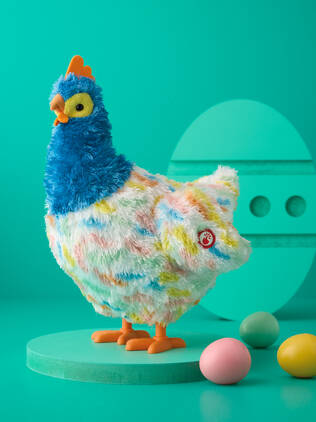 Stuffed animal hen on teal background with multiple easter eggs in the foreground.