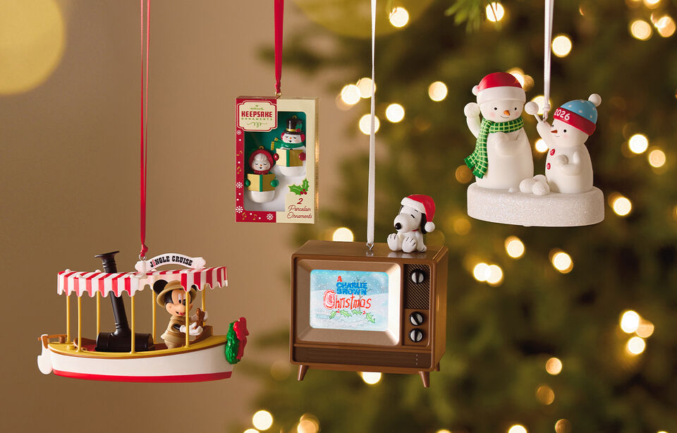 Holiday-themed Keepsake Ornaments hanging on a Christmas tree.