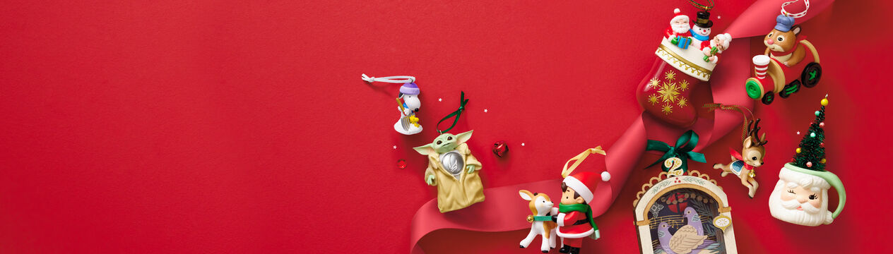 Ornaments spread across a red background like Grogu™, a reindeer, Snoopy shoveling snow and more
