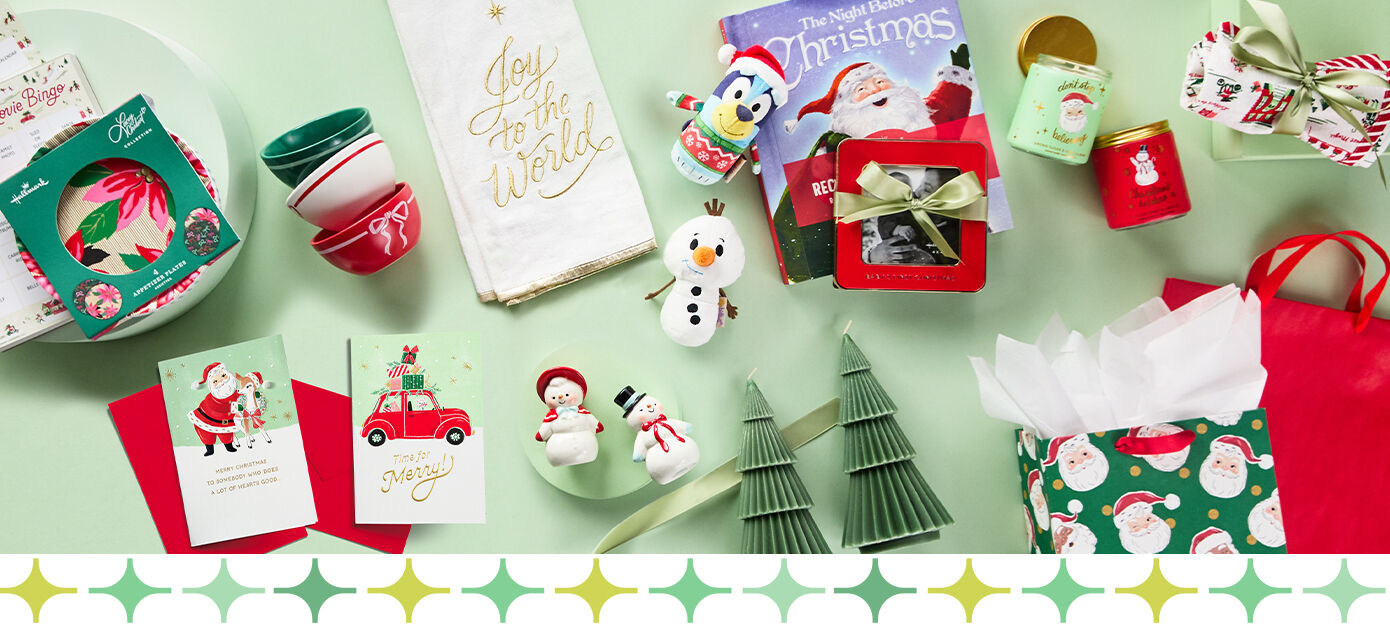 Various Christmas gifts, wrap and cards on a mint green background