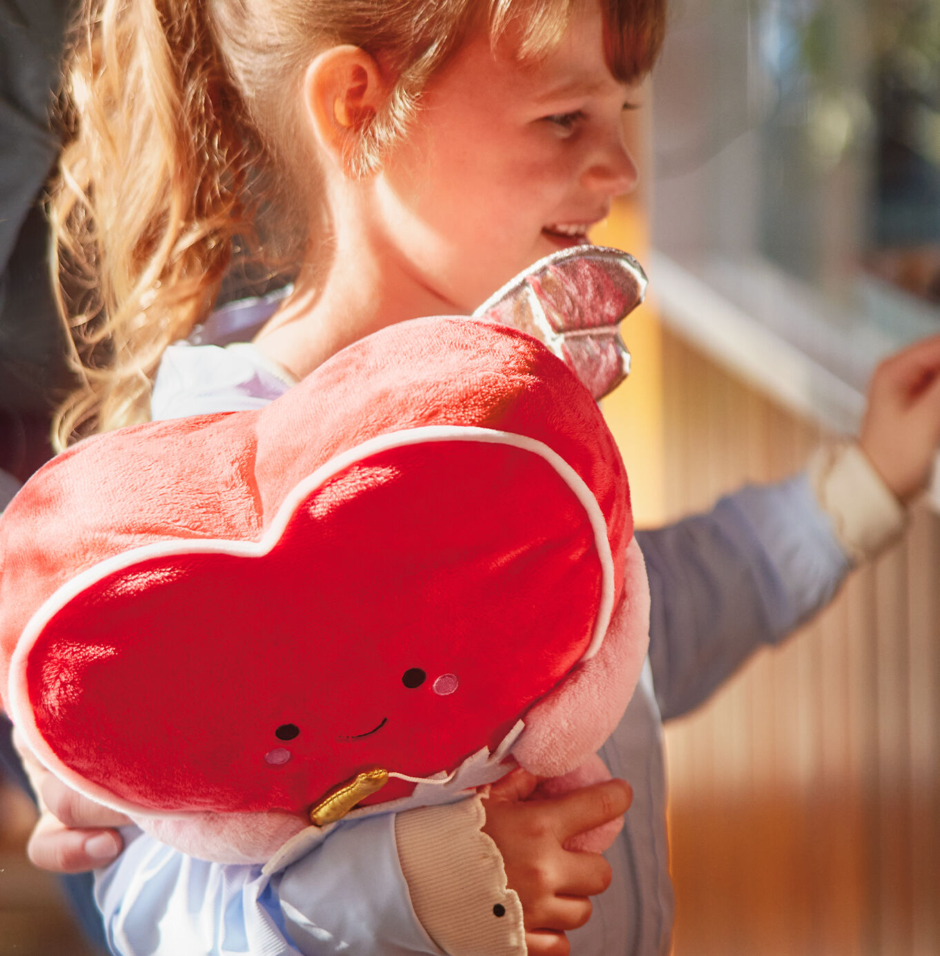 Girl holding a Valentines heart plush