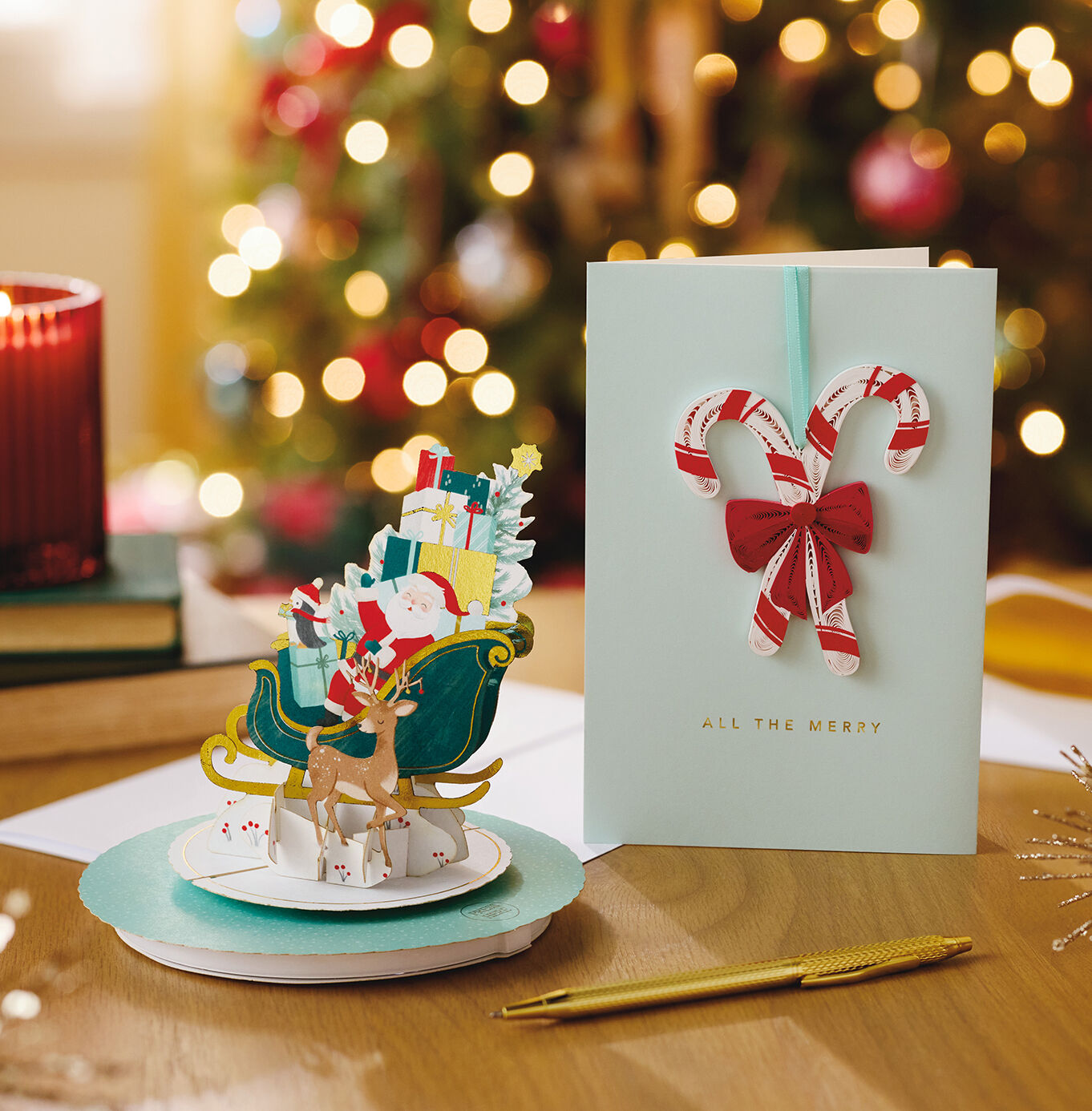 Two Hallmark Christmas cards on a table with a pen