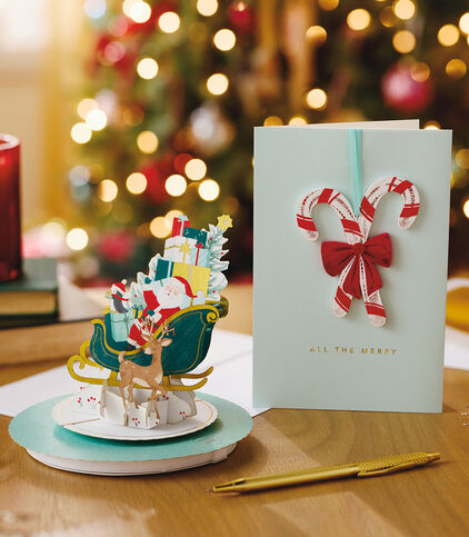 Two Hallmark Christmas cards on a table with a pen