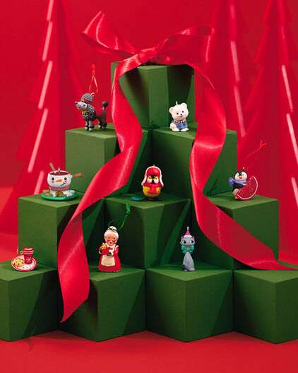 Holiday-themed miniature ornaments on green pedestals. 