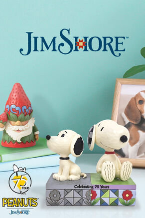 Jim Shore gnome figurine and 75th Anniversary Snoopy Jim Shore figurine on a table.
