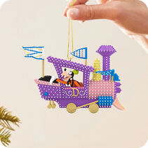 Hand holding an ornament of Goofy in a purple, pink and blue stylized train