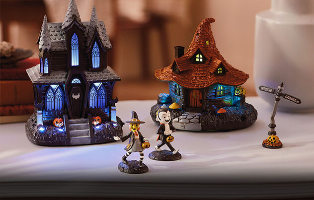 Halloween-themed house, hut, street sign and characters on a table. 