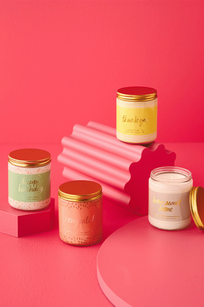 Four candles with gold sentiments printed on the label. 
