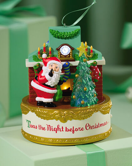 Santa shushing in front of a fireplace ornament