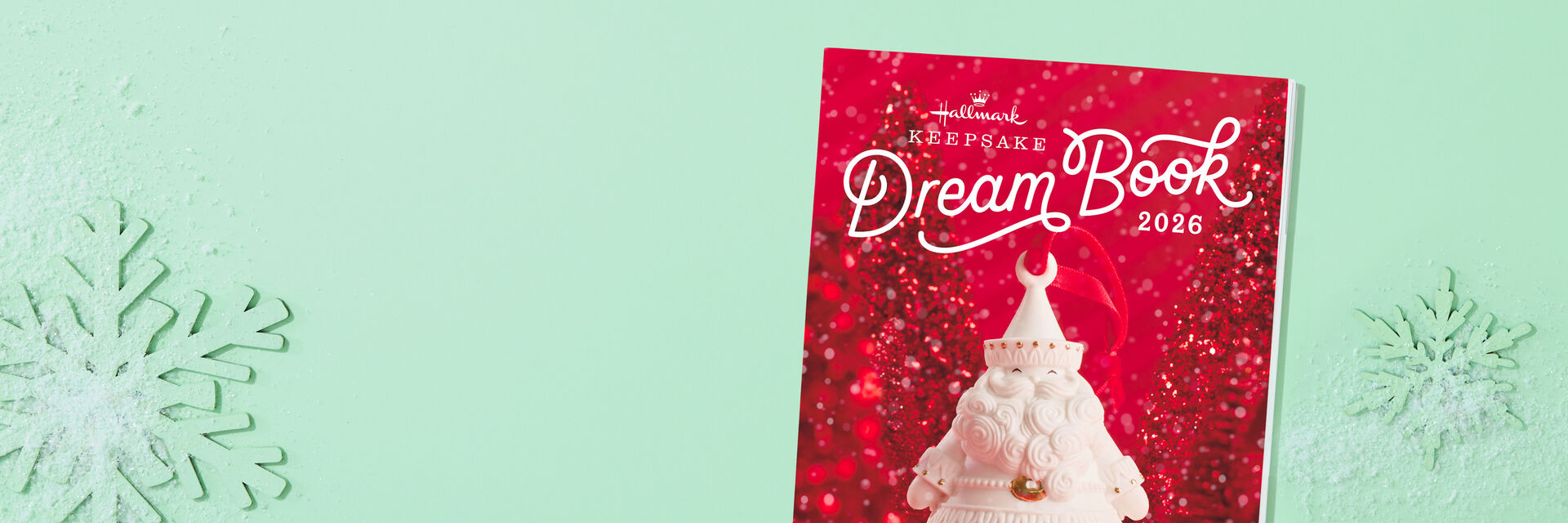  Hallmark Keepsake Dream Book 2026 red cover with white Santa ornament. Light green background with snowflakes.