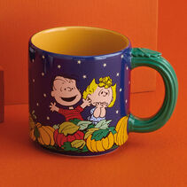 Mug with Great Pumpkin movie scene on dark blue background and orange interior with stem-shaped handle and leaf thumb rest