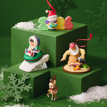 4 ornaments from Hallmark Keepsake series on green background with snowflakes