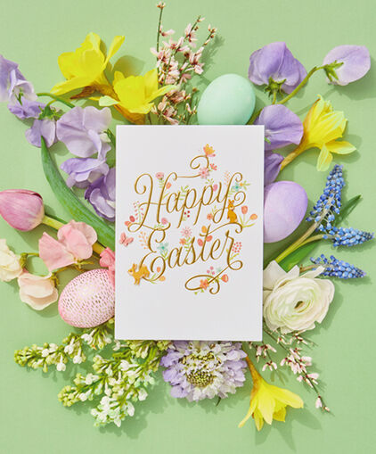 Easter card laying on spring flowers and Easter eggs.